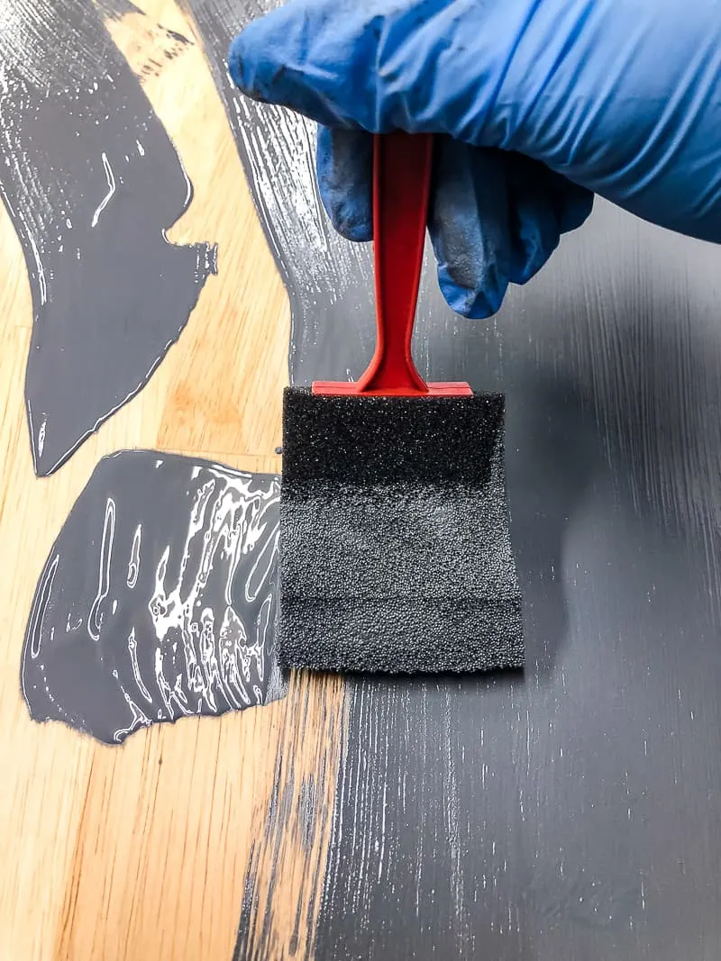 applying gray gel stain to a table top